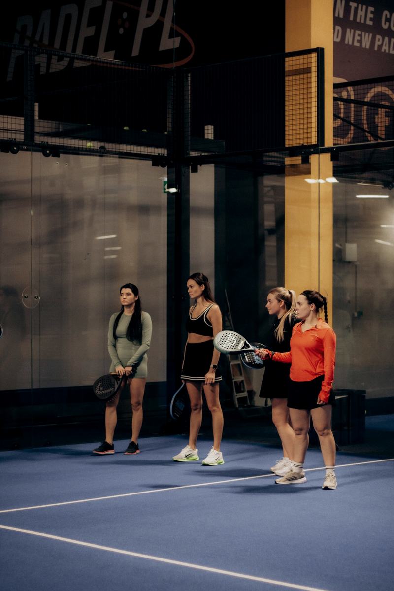 Group padel clinic lined up on an indoor court
