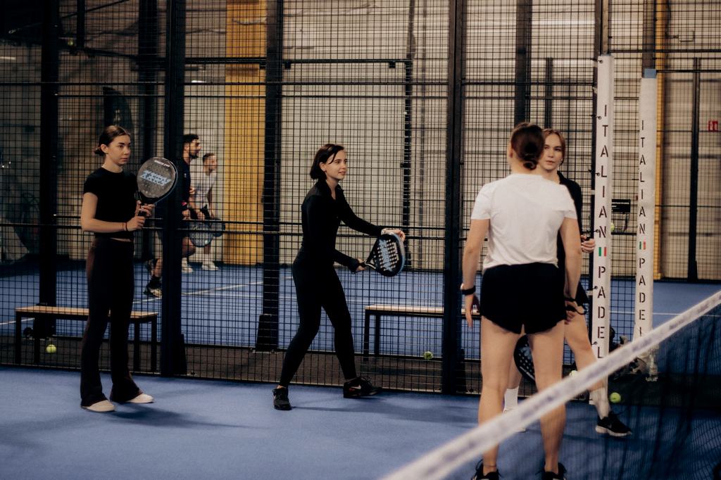 Players warming up together on an indoor padel court